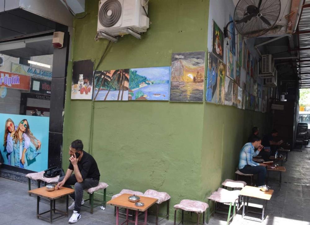 Çay ocağında hem kitap okuyorlar hem çay içiyorlar