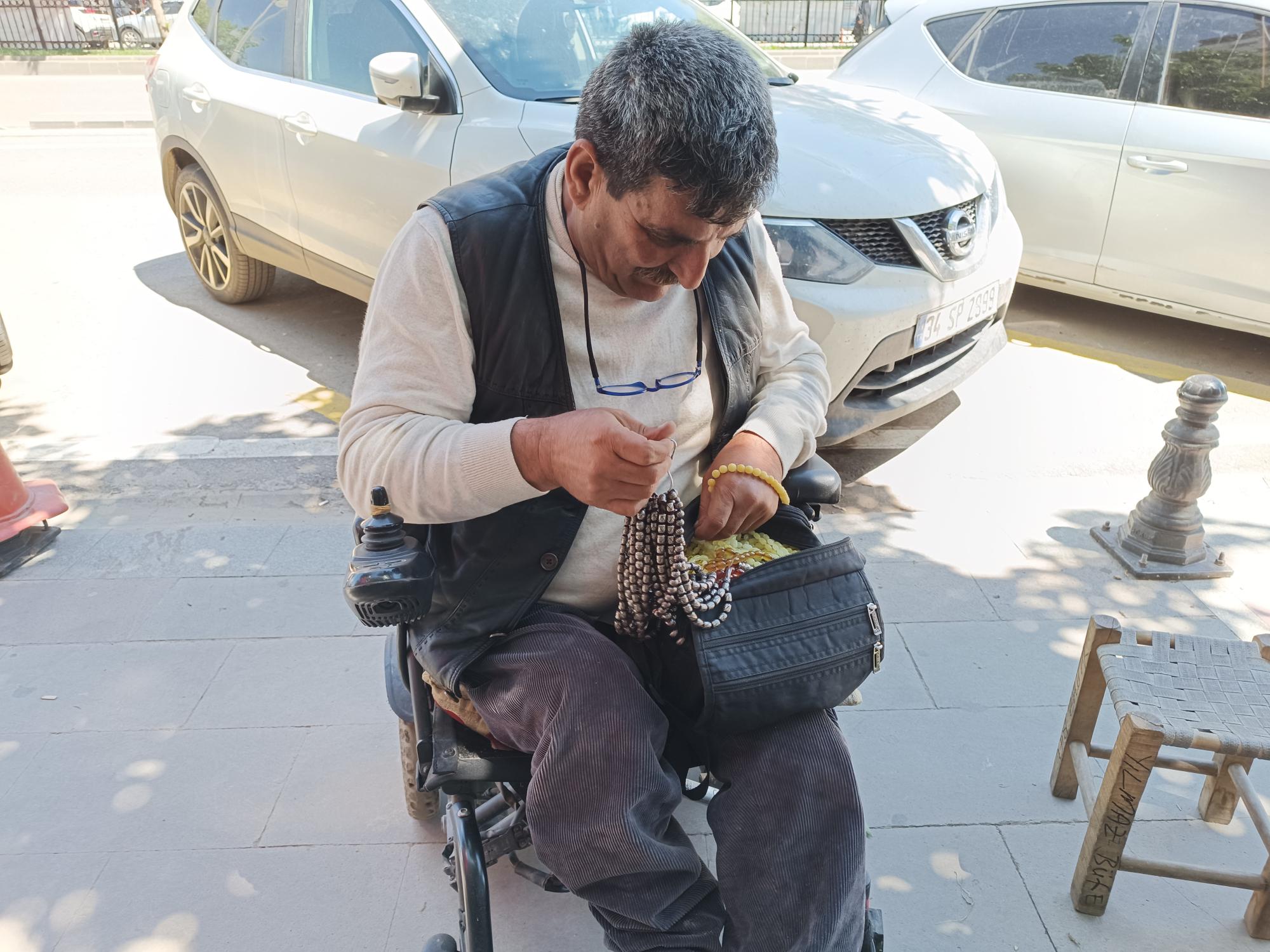 Akülü aracıyla ekmeğinin peşinde